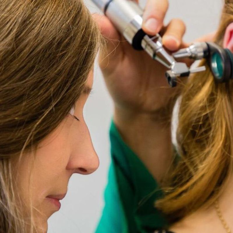 audiologist checking a patient's ear